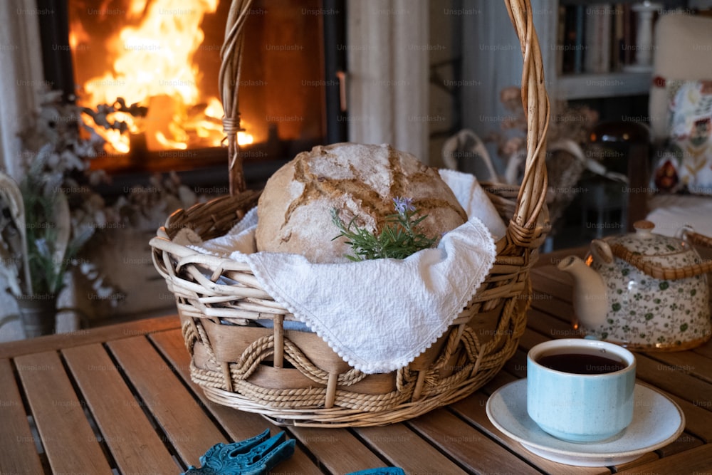 uma cesta cheia de pão ao lado de uma xícara de café
