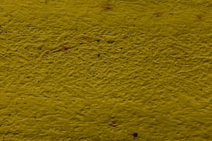 un primo piano di un muro giallo con un po 'di sporcizia su di esso