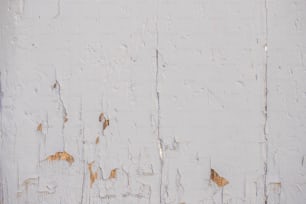 eine alte weiß gestrichene Wand mit abblätternder Farbe