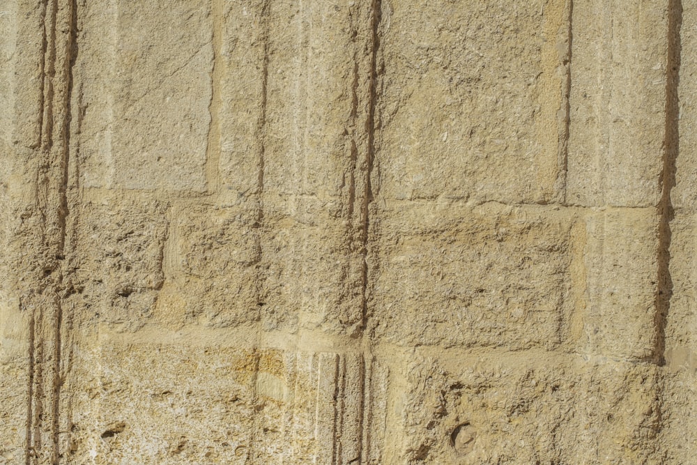 a close up of a stone wall with a clock on it