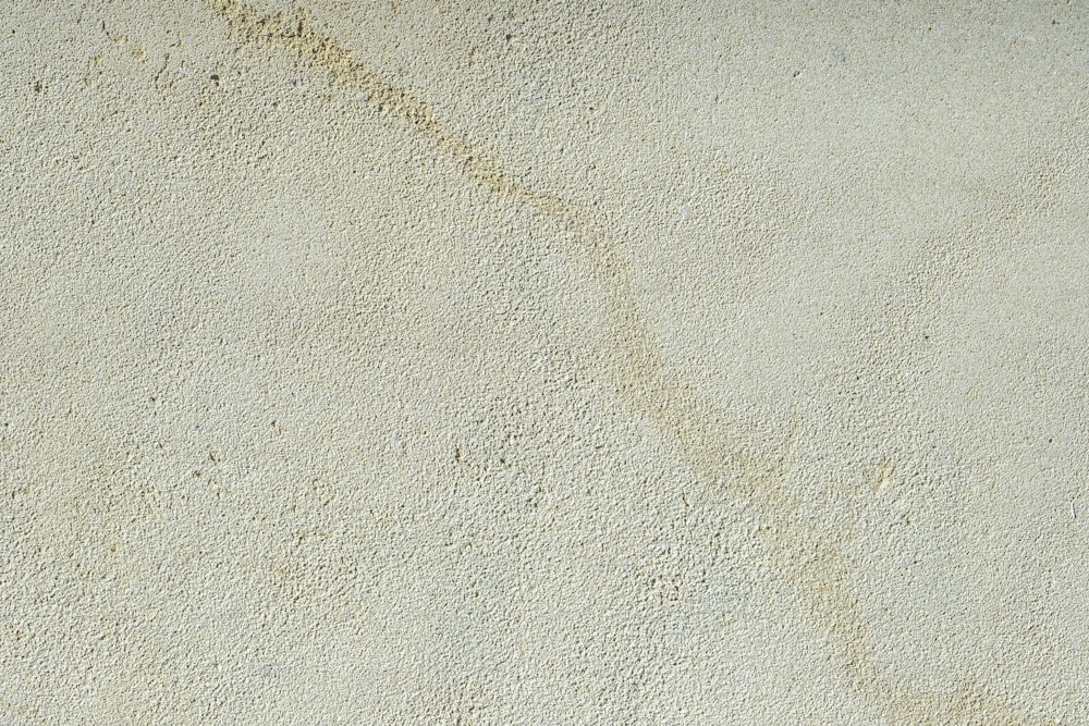 un gros plan d’un mur avec du sable dessus