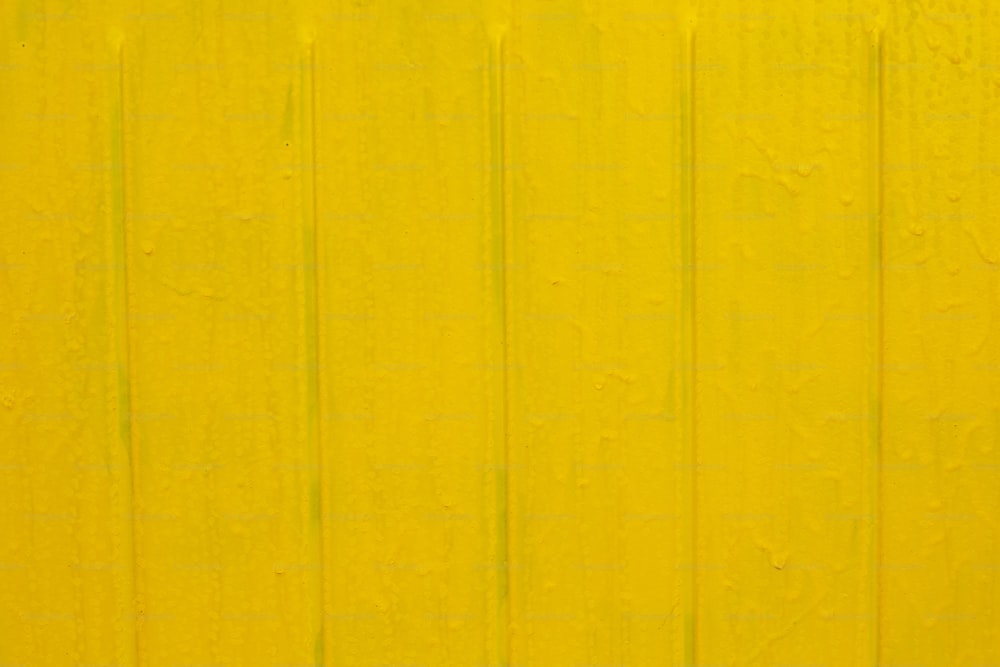 un muro giallo con un segnale di stop rosso su di esso