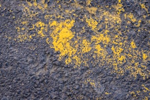a close up of yellow paint on a black surface