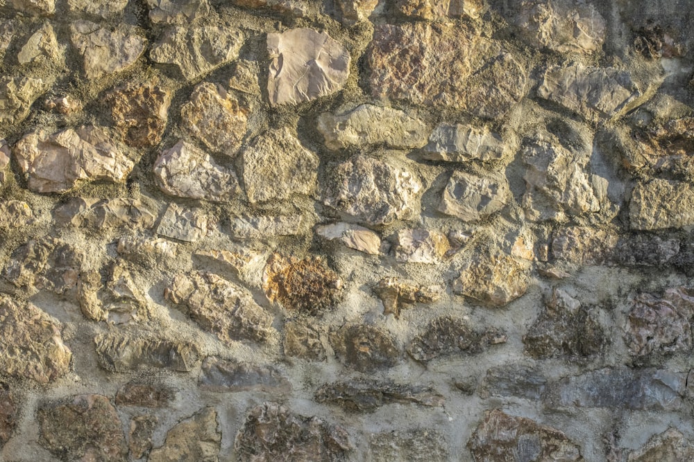 Un primer plano de un muro de piedra con un reloj