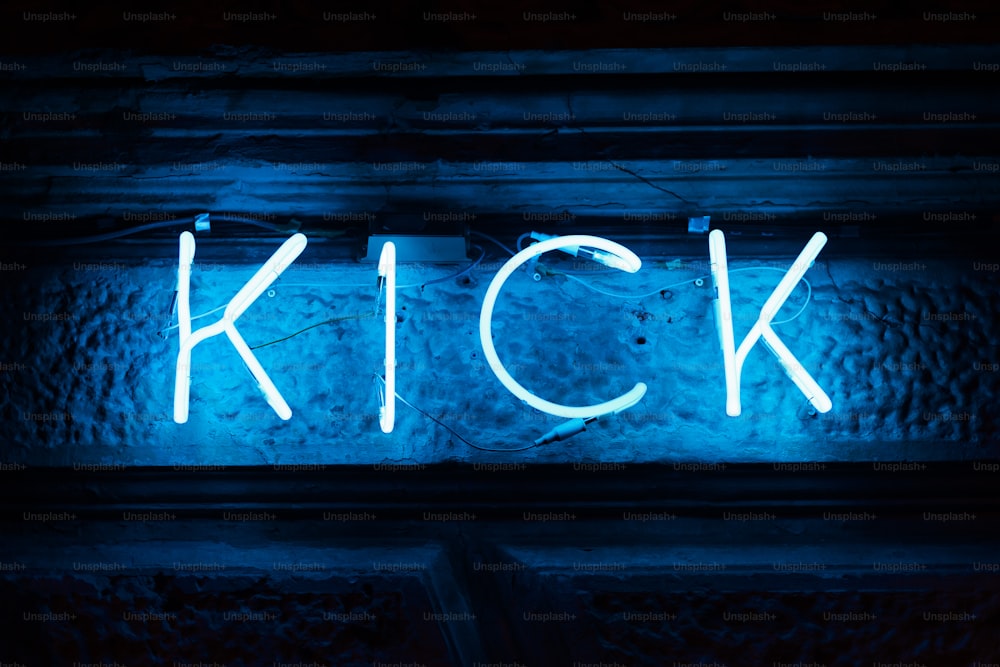 a neon sign that reads kick on a wall
