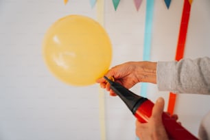 a person holding a balloon and a blow dryer