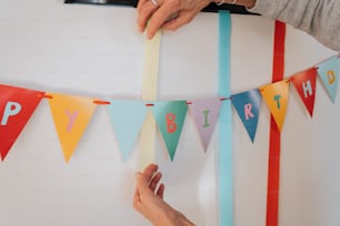 a person placing a happy birthday banner on a wall