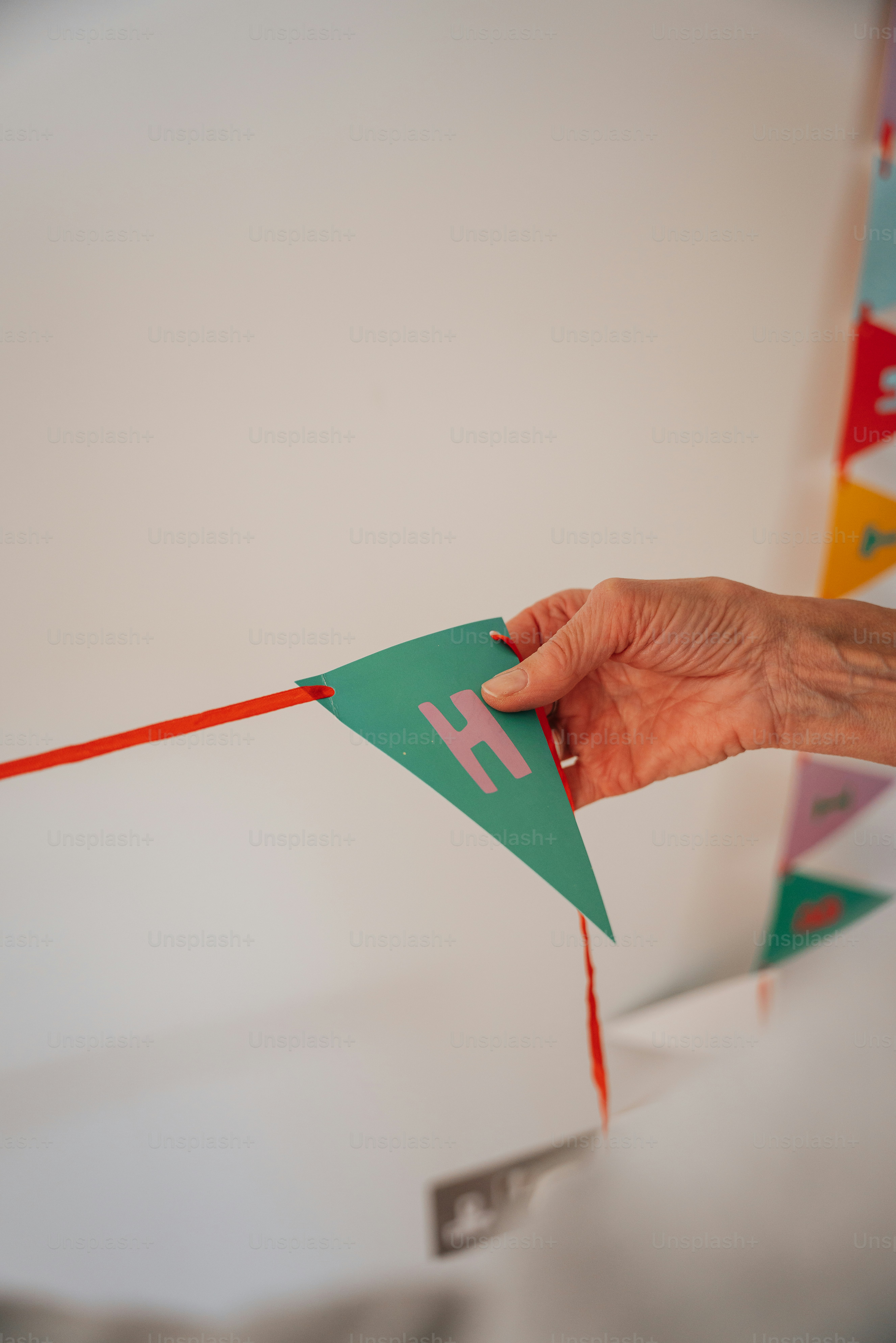 uma mão segurando um pedaço de papel com uma corda vermelha