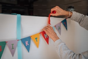 Una mujer está decorando una pancarta de cumpleaños