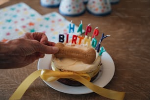 Una persona está sosteniendo un pastel de cumpleaños con velas