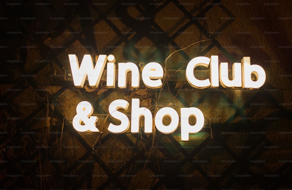 uma placa de néon que diz clube de vinhos e loja