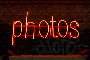 a red neon sign that reads photos