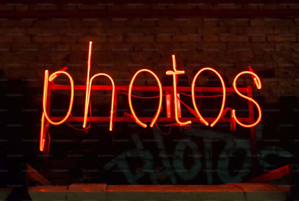 a red neon sign that reads photos