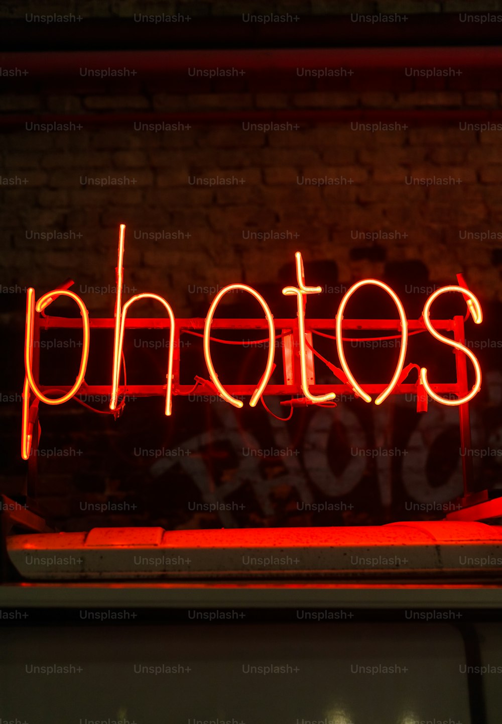 Une enseigne au néon rouge qui dit photos