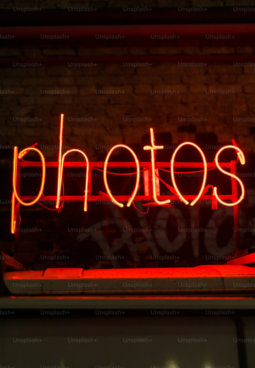 a red neon sign that says photos