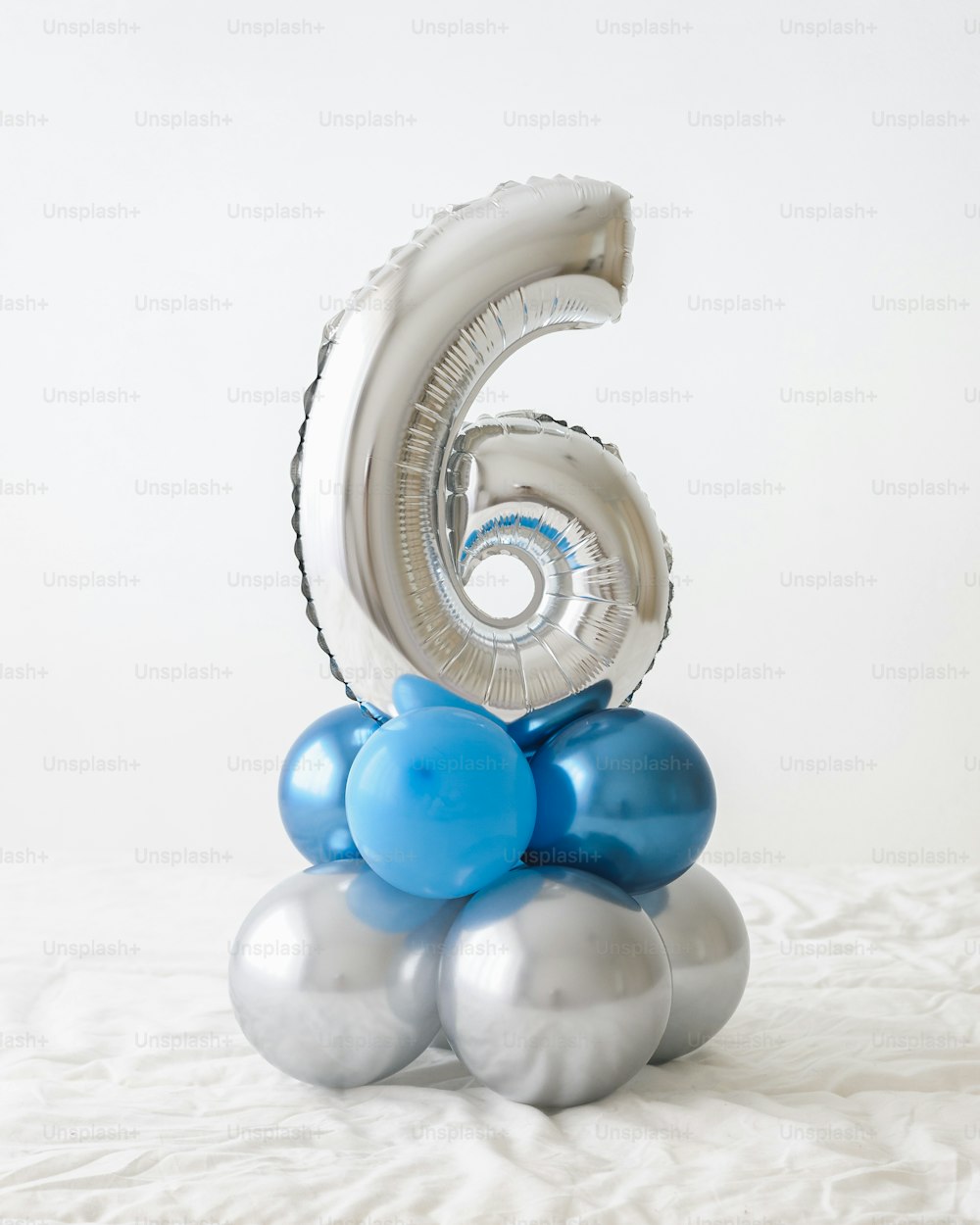 um balão número seis sentado em cima de um monte de balões