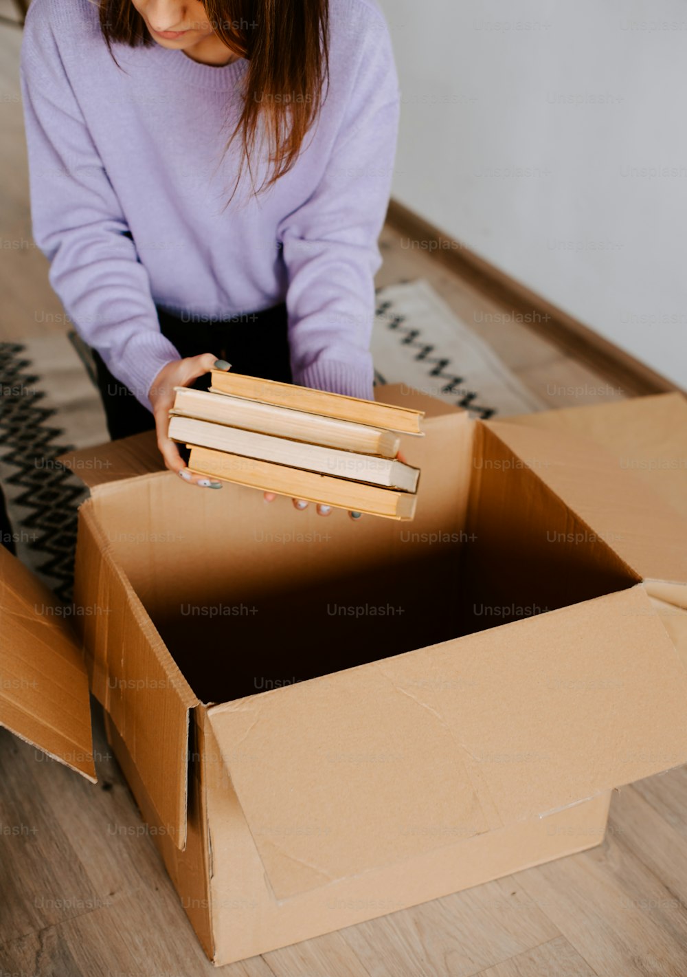 a girl is opening a box on the floor
