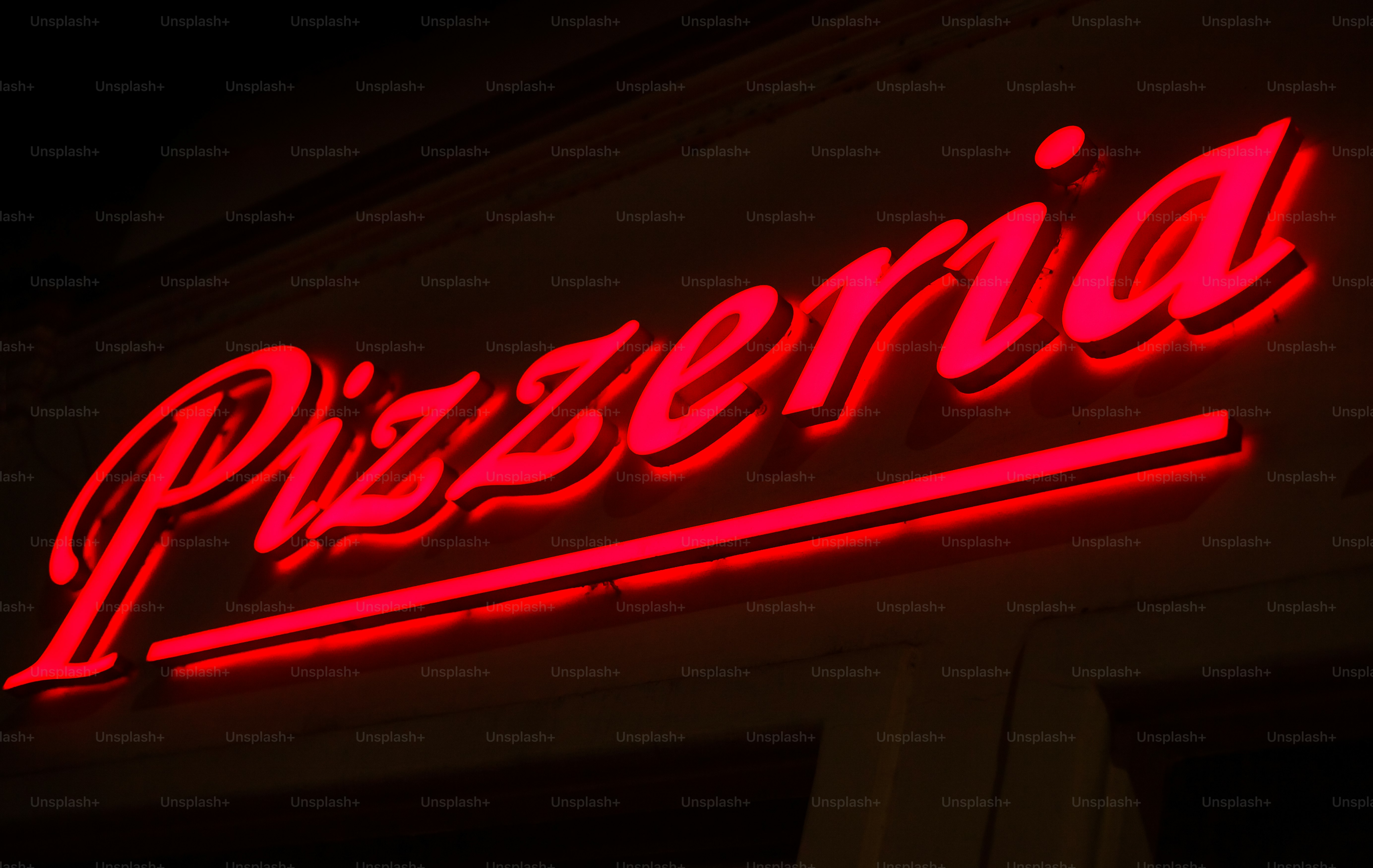a red neon sign that says pizzeria on the side of a building
