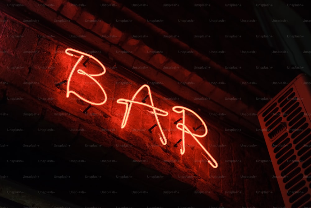 Eine Leuchtreklame, auf der Bar an einer Ziegelmauer steht