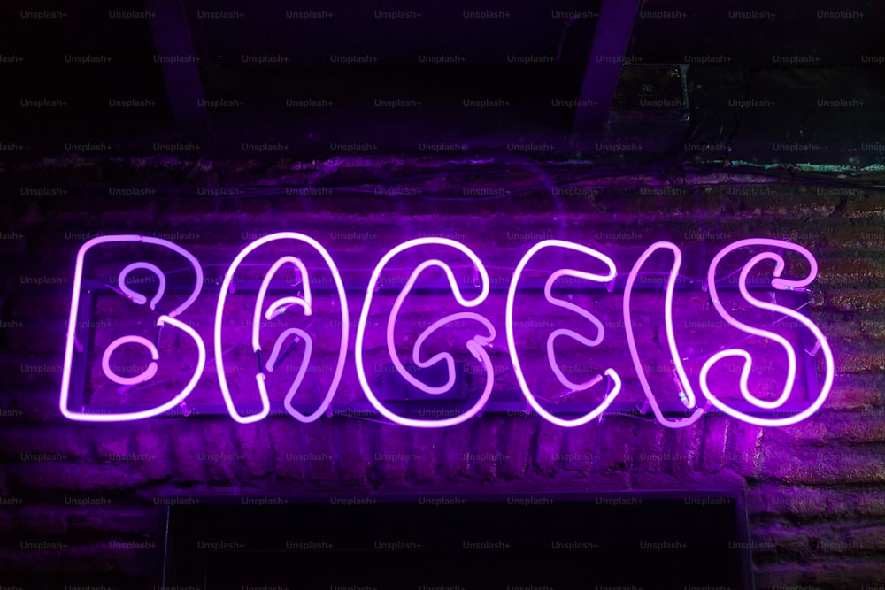 a neon sign that says bacces on a brick wall