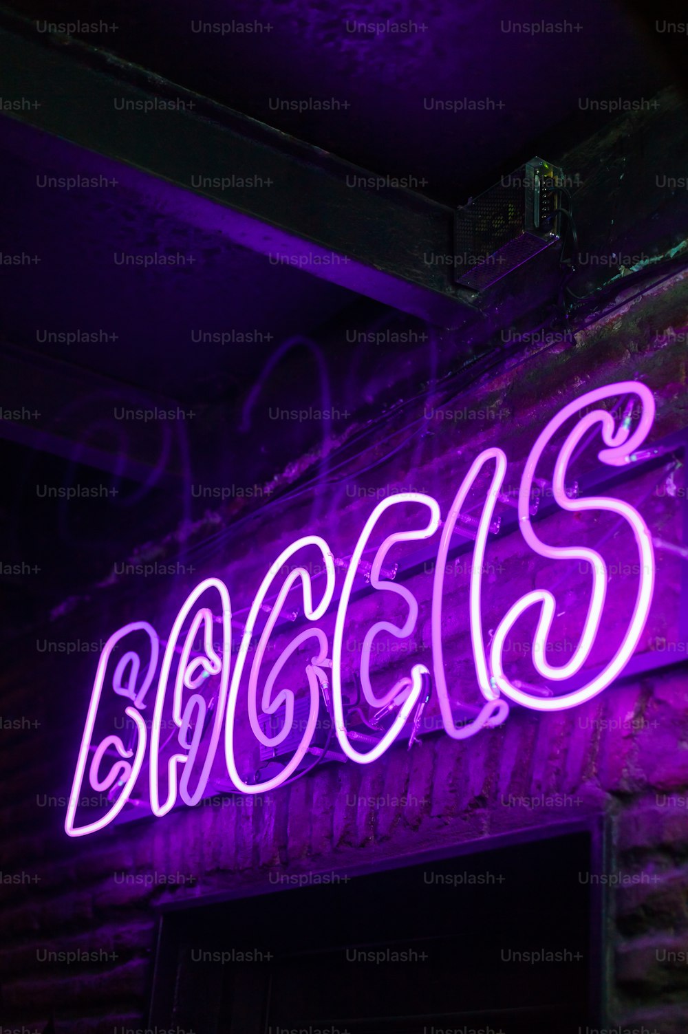 レンガの壁にバクシーズと書かれた紫色のネオンサイン