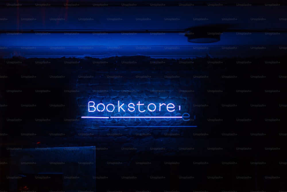 a neon sign that reads bookstore on a brick wall