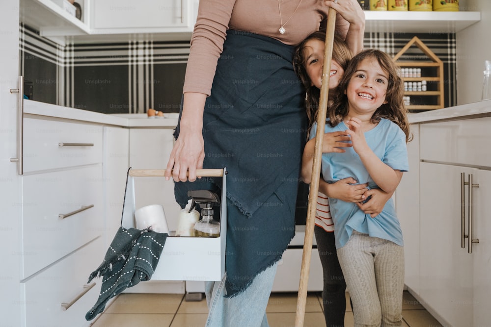 a woman standing next to a little girl in a kitchen