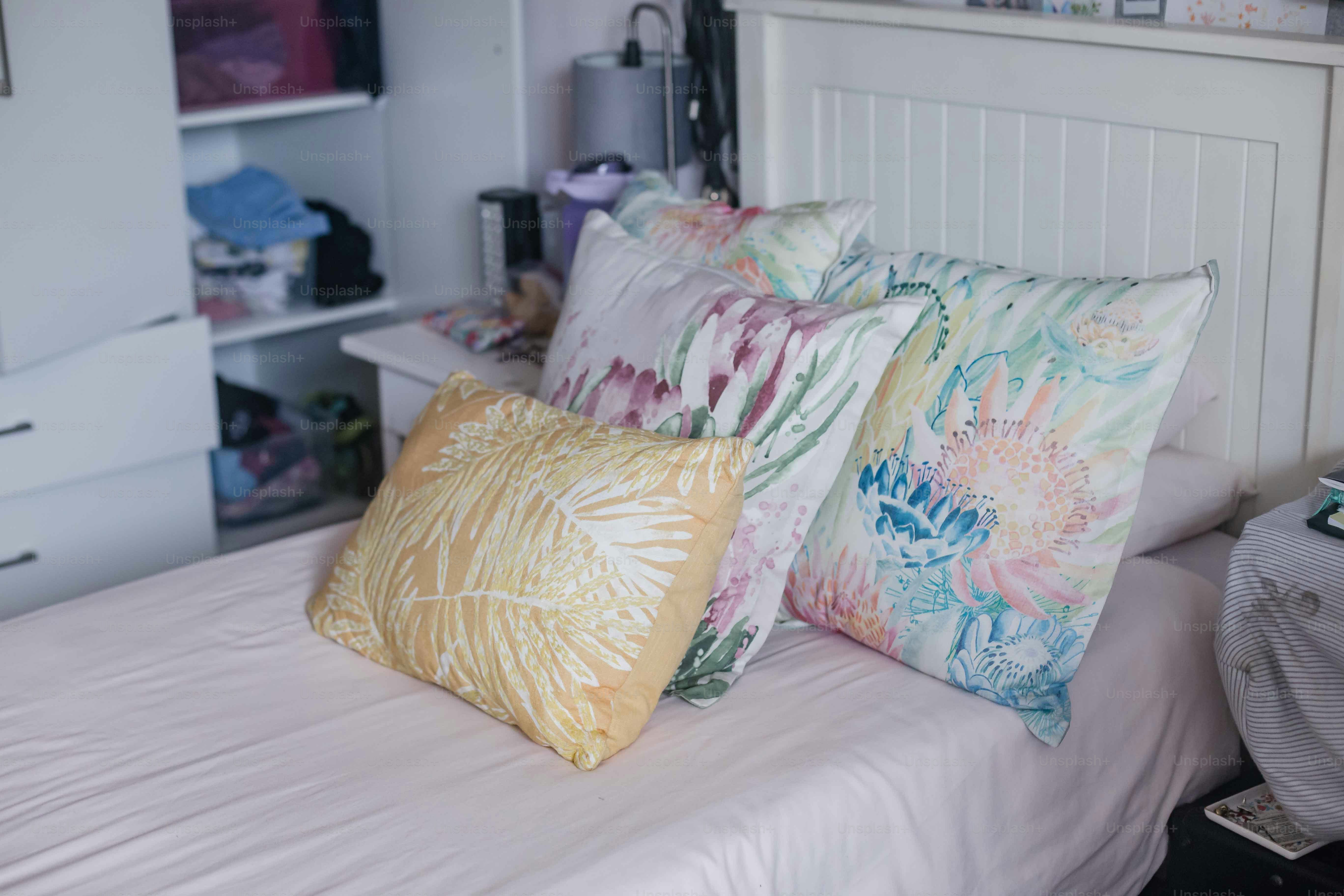 a bed with three pillows on top of it