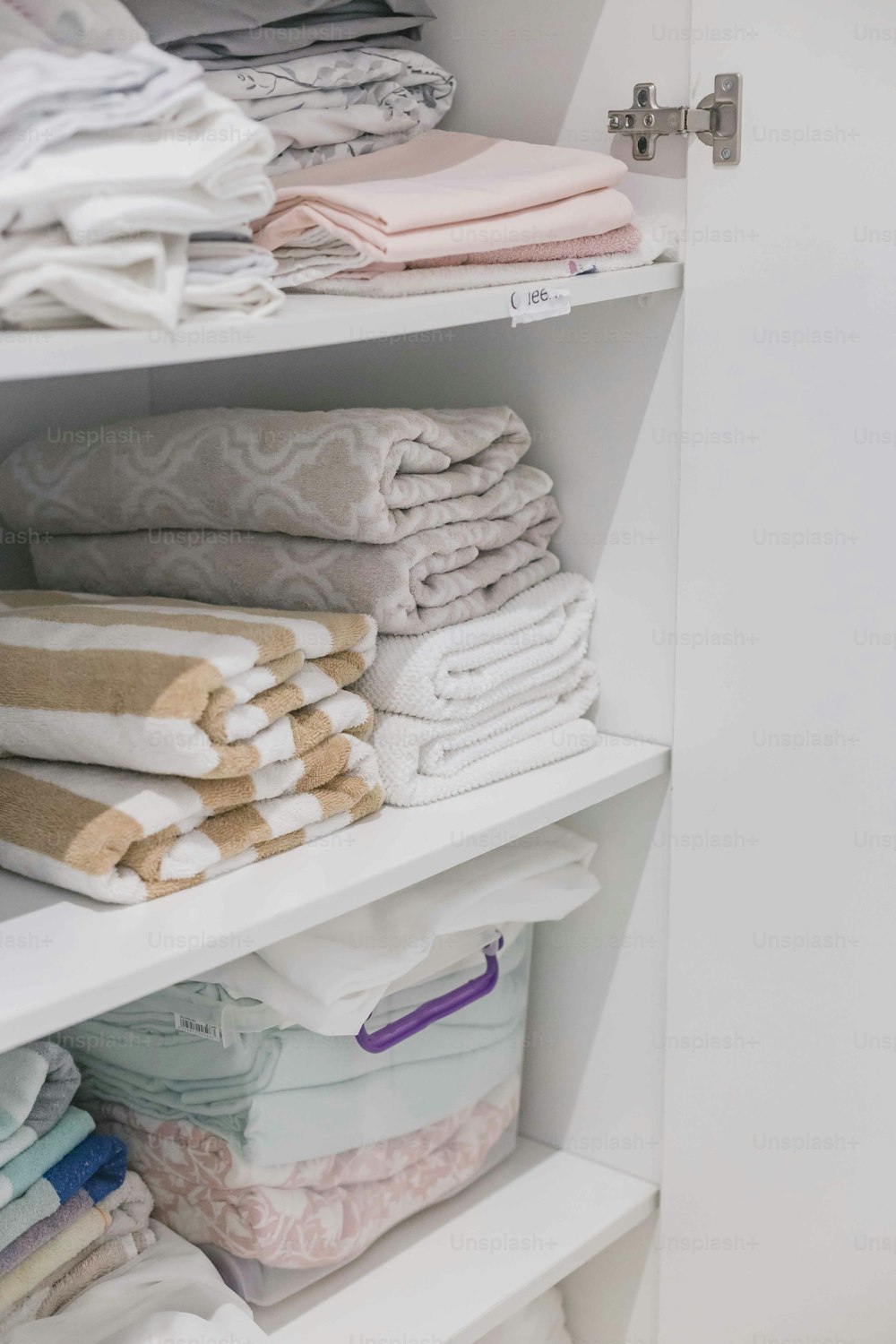 um armário cheio de toalhas dobradas e cobertores dobrados