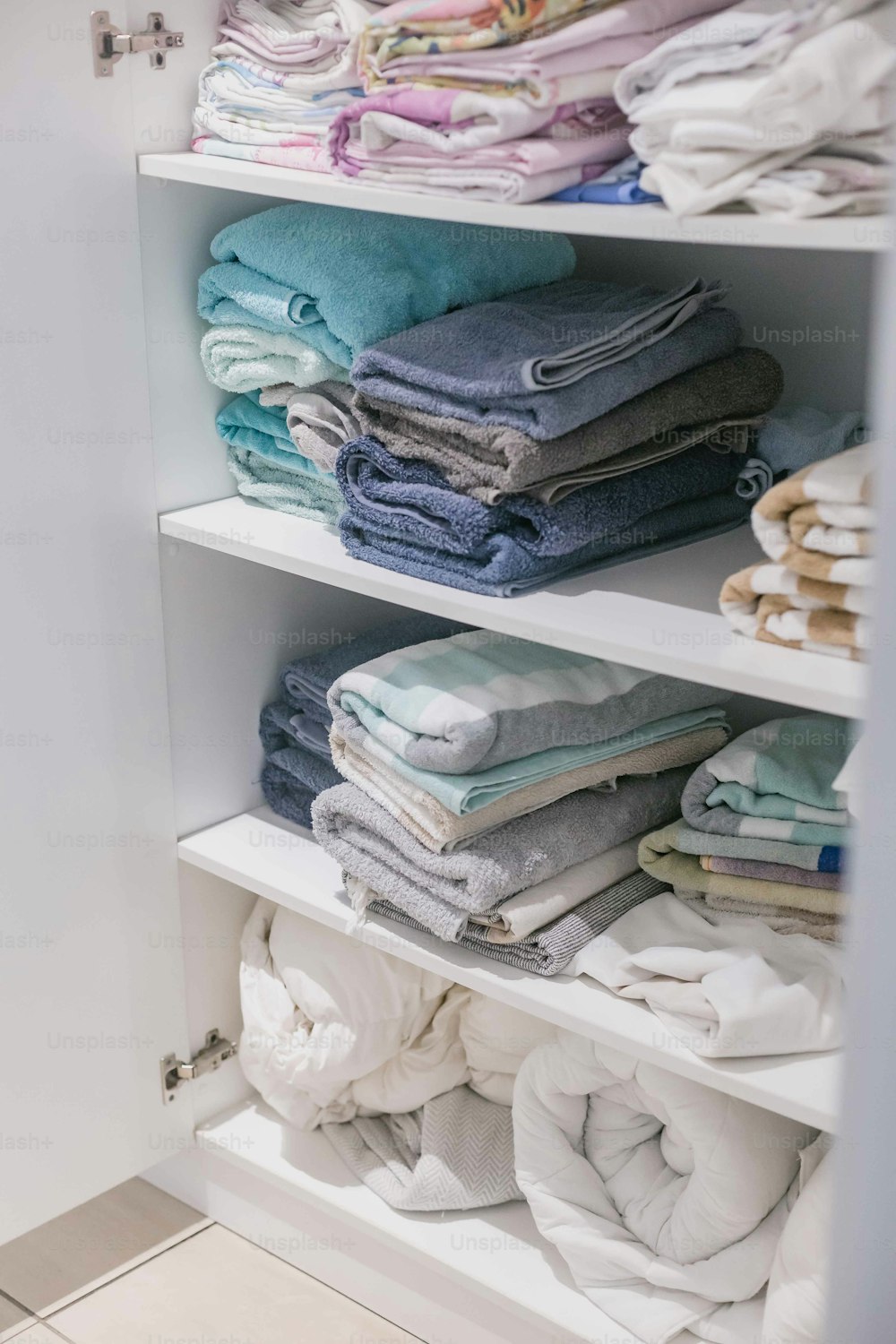 a closet filled with lots of folded clothes