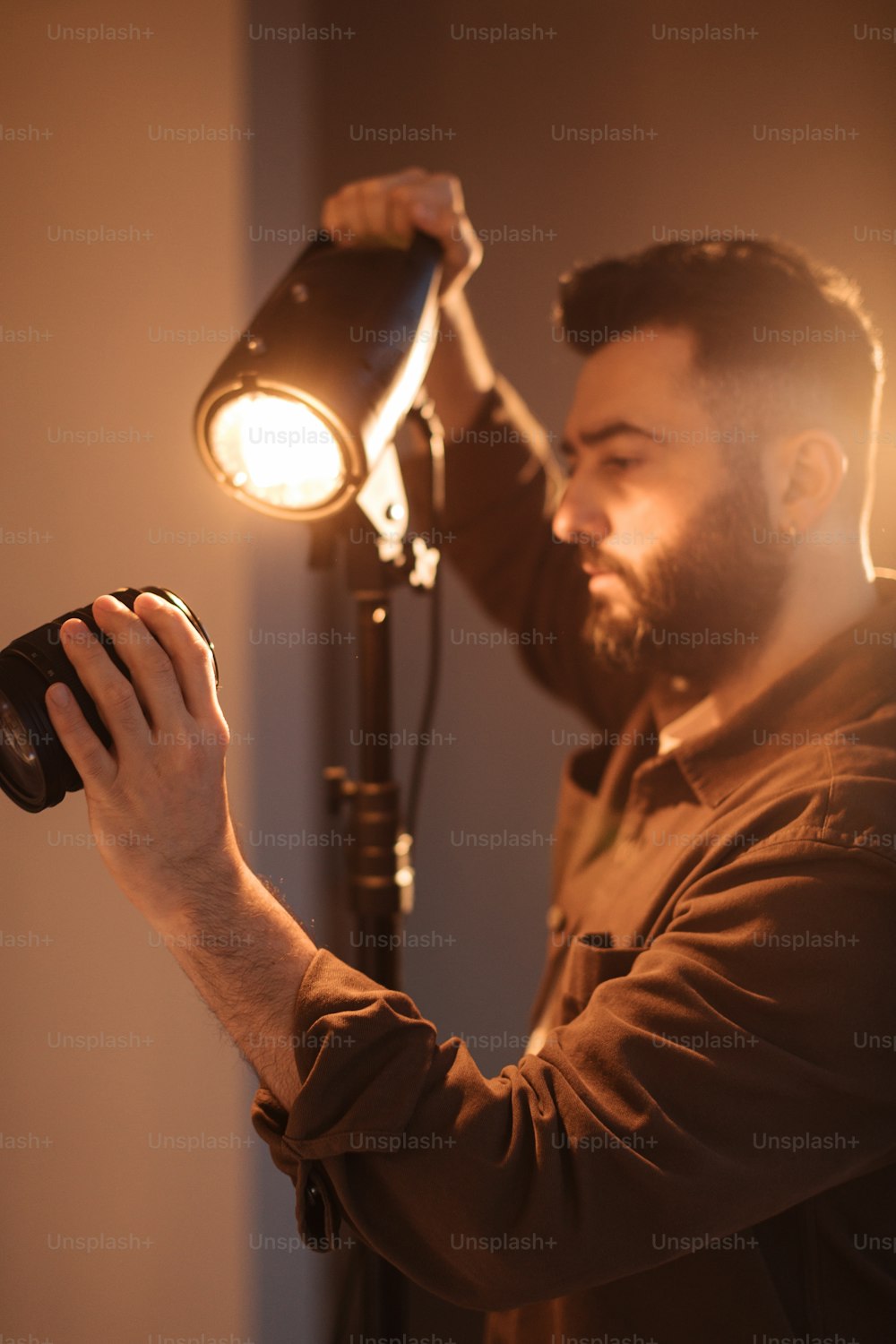 um homem segurando uma câmera até uma luz