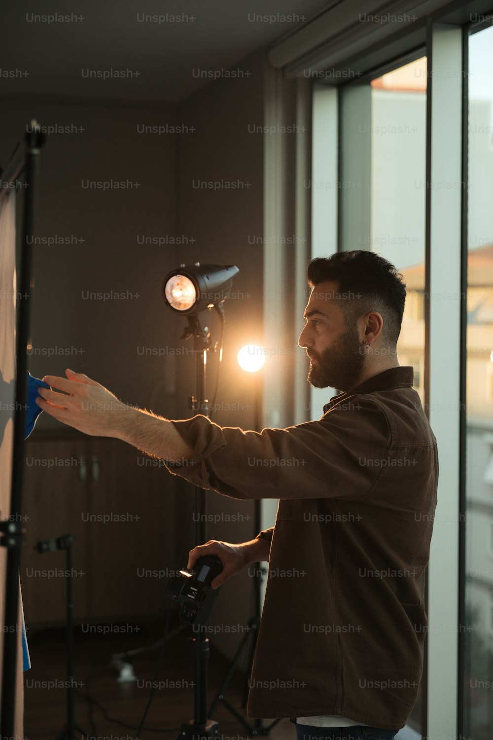 um homem em pé na frente de uma câmera segurando uma luz