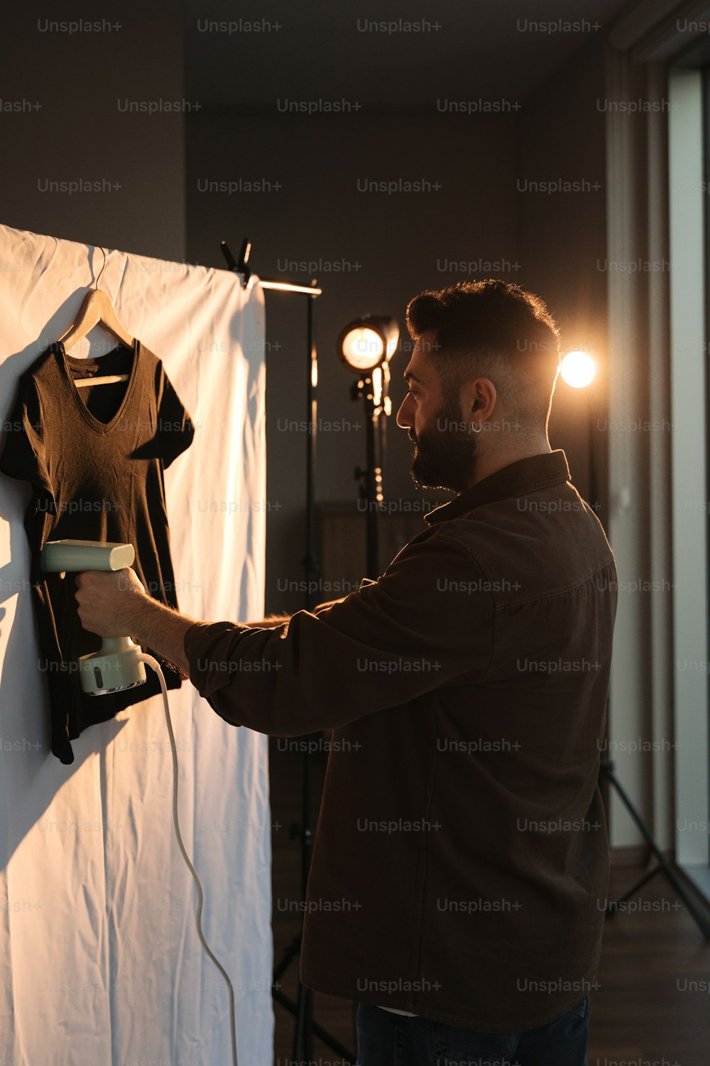 a man is lighting a t - shirt on a wall