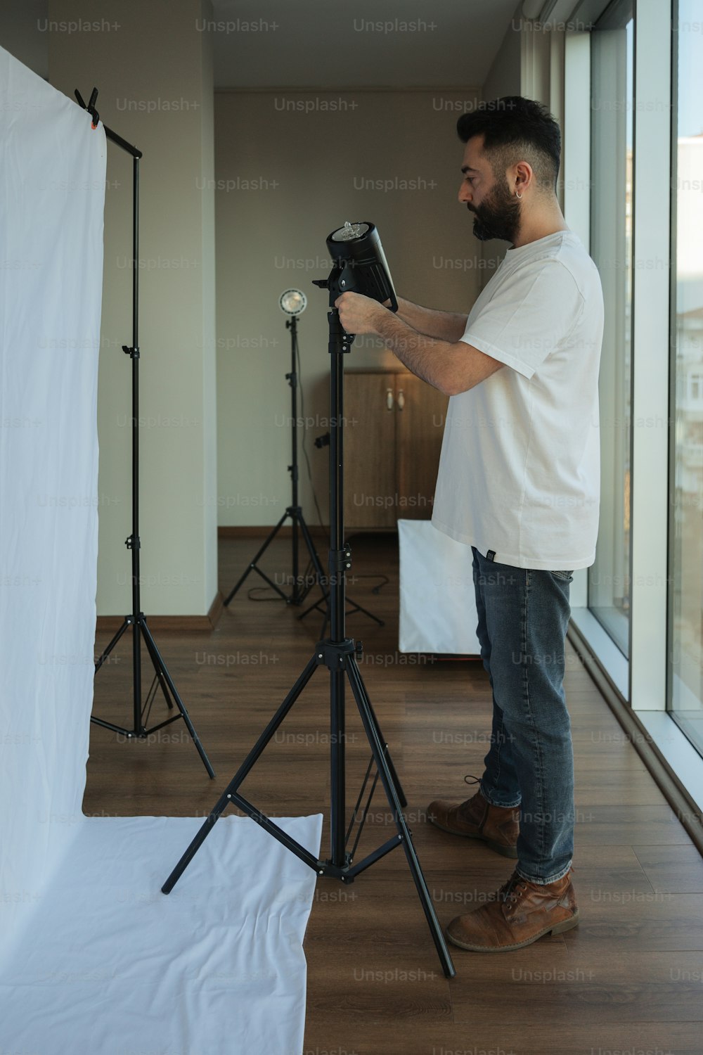 Un hombre parado frente a una cámara en un trípode