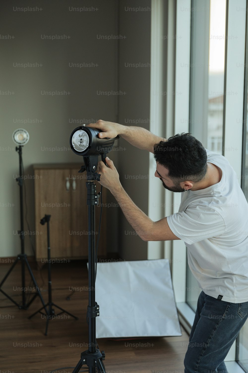 a man adjusting a clock on a tripod