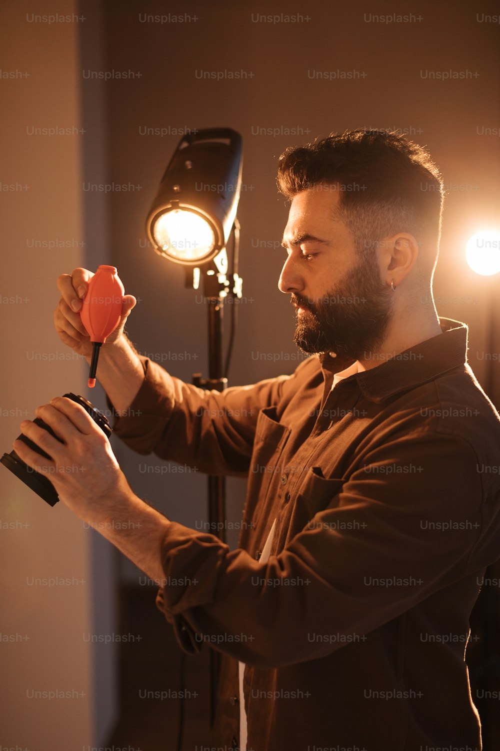a man holding a red object in front of a light