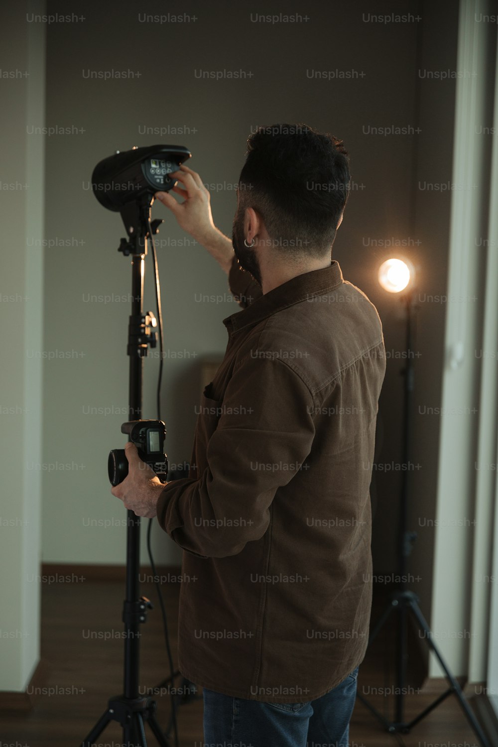 Ein Mann steht vor einer Kamera auf einem Stativ