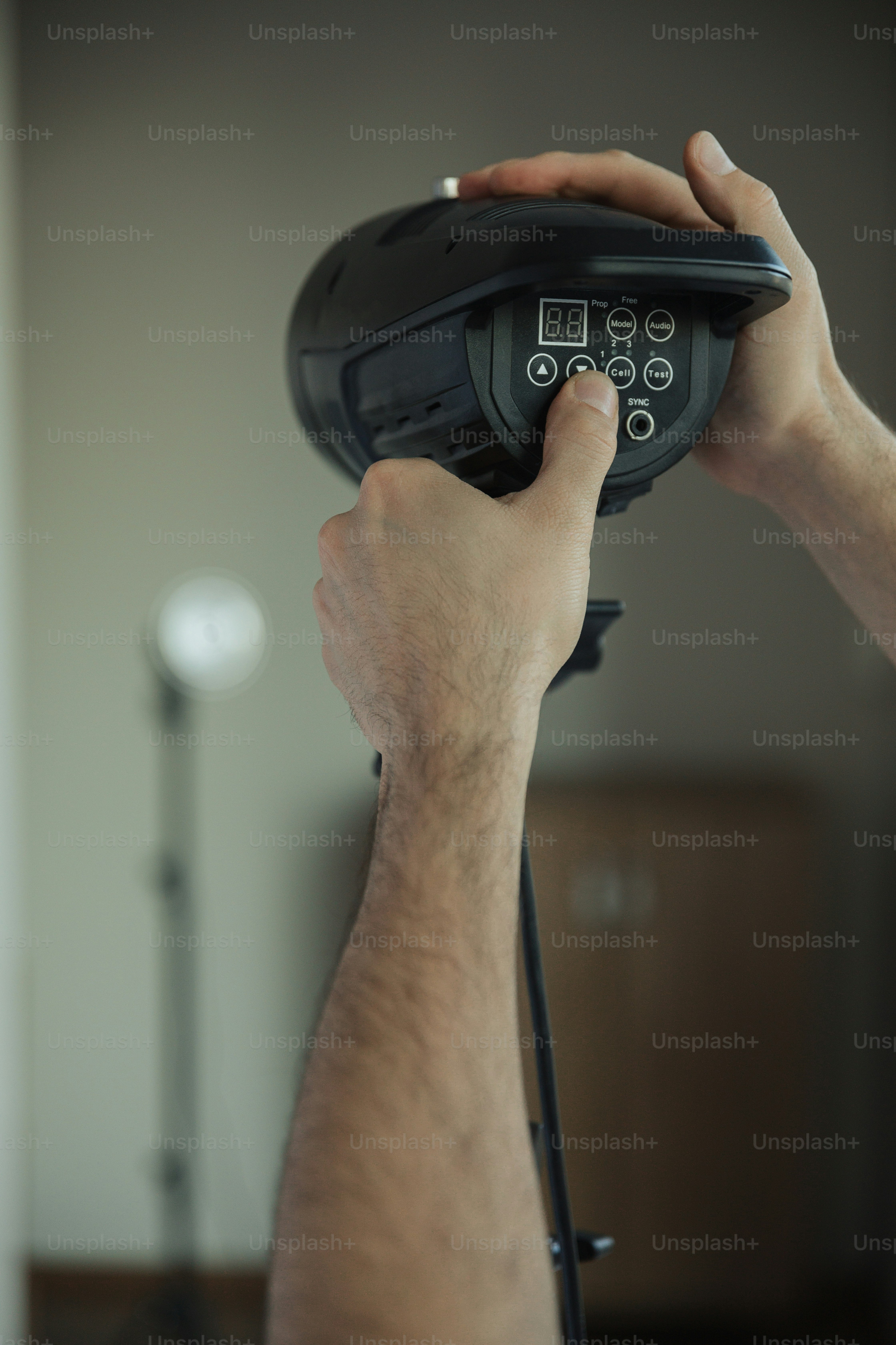 A man holding a remote control in his hand photo – Photographer Image ...