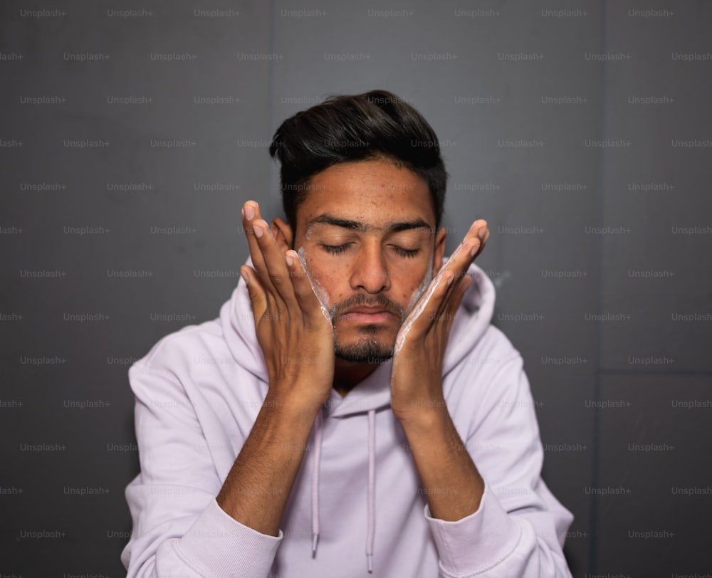 a man holding his hands to his face