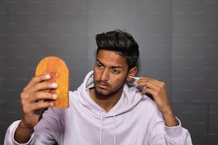 a man in a white hoodie holding a piece of bread