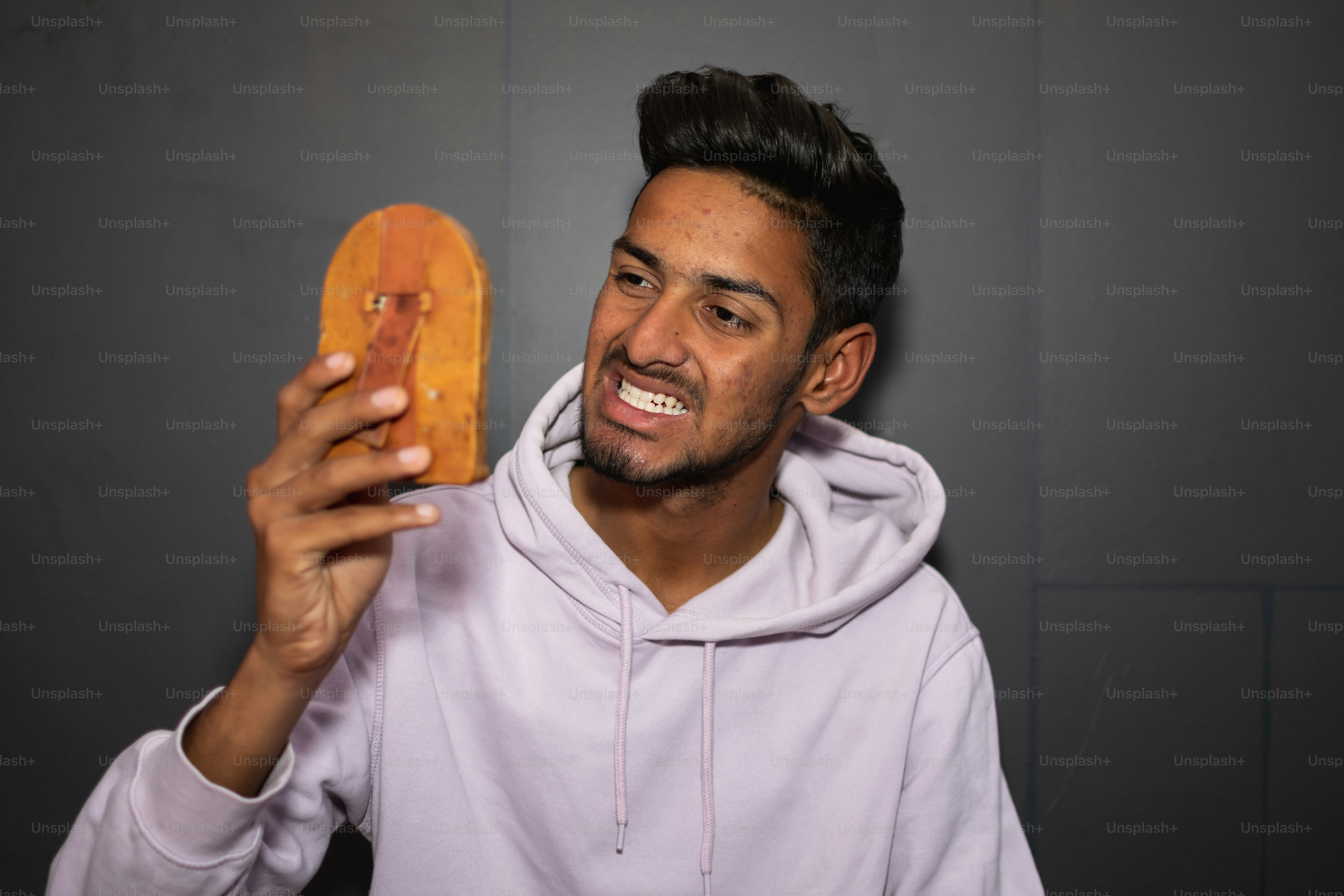 Ein Mann im Kapuzenpulli hält einen Donut in der Hand