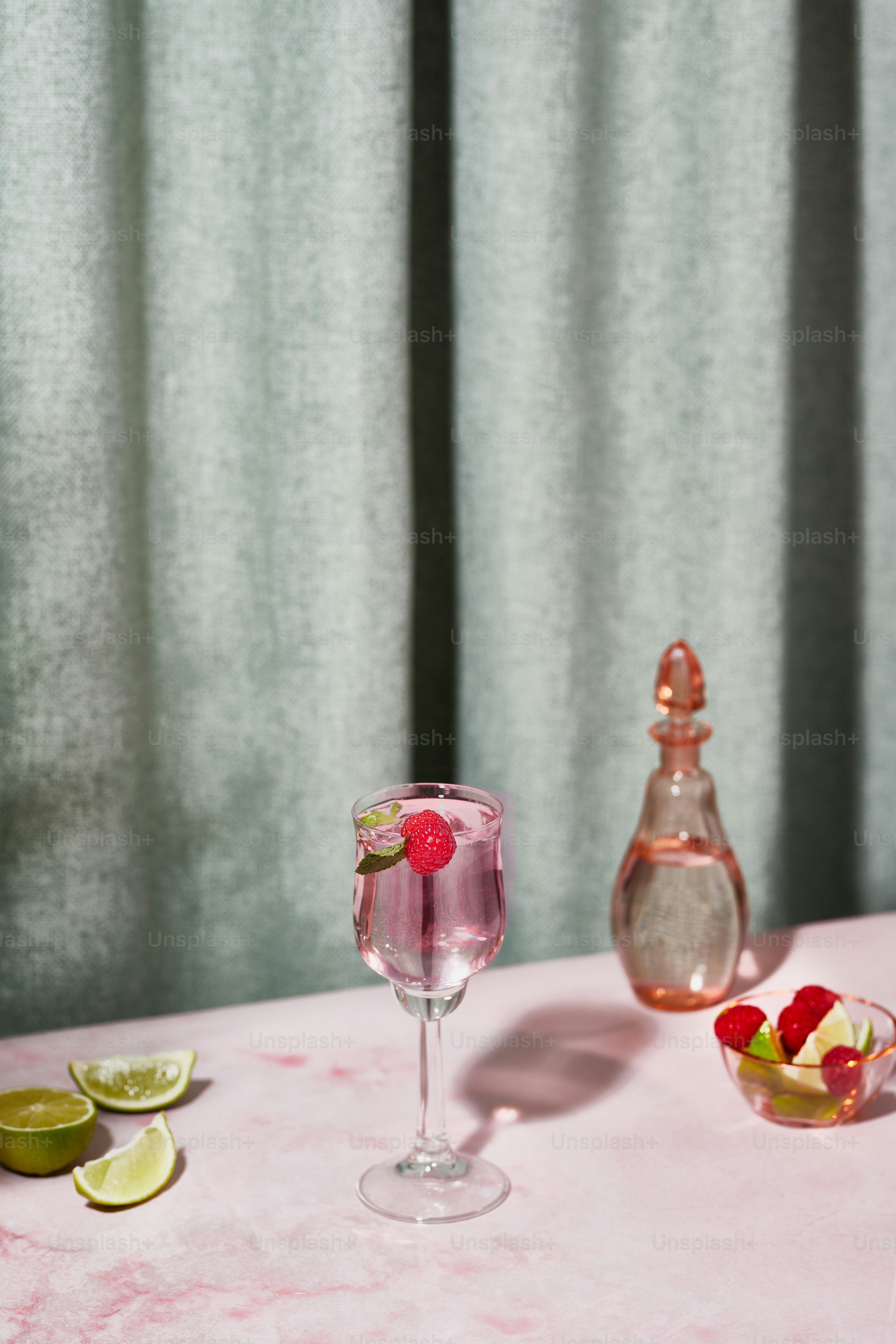 a pink table topped with a wine glass filled with liquid