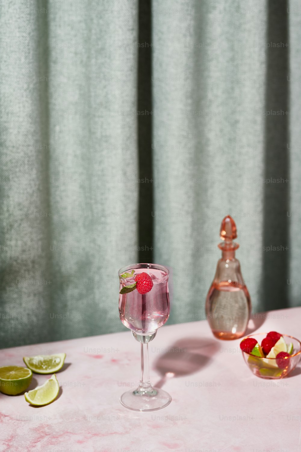 액체로 채워진 와인 잔을 얹은 분홍색 테이블