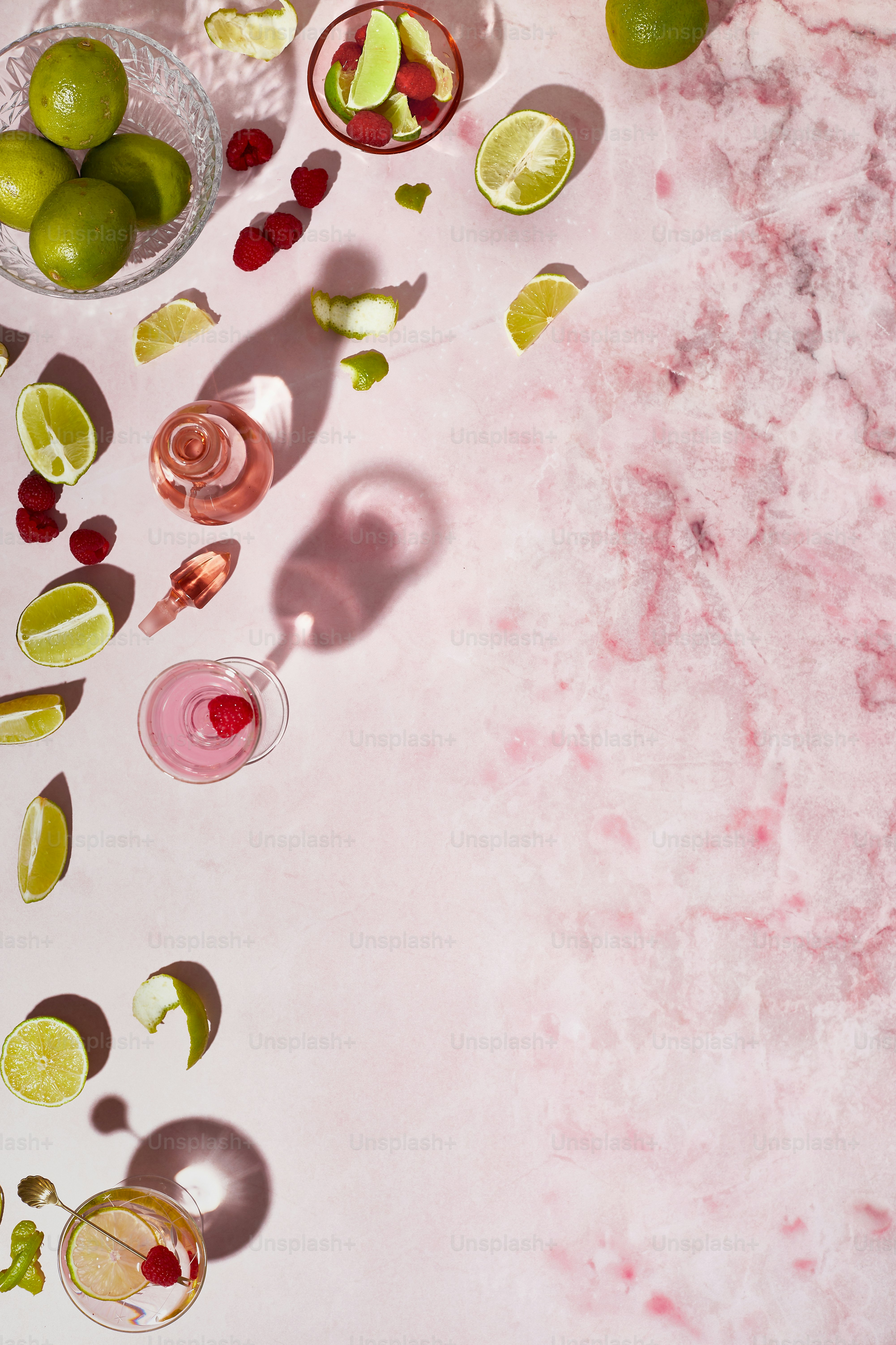 a table topped with glasses of drinks and limes