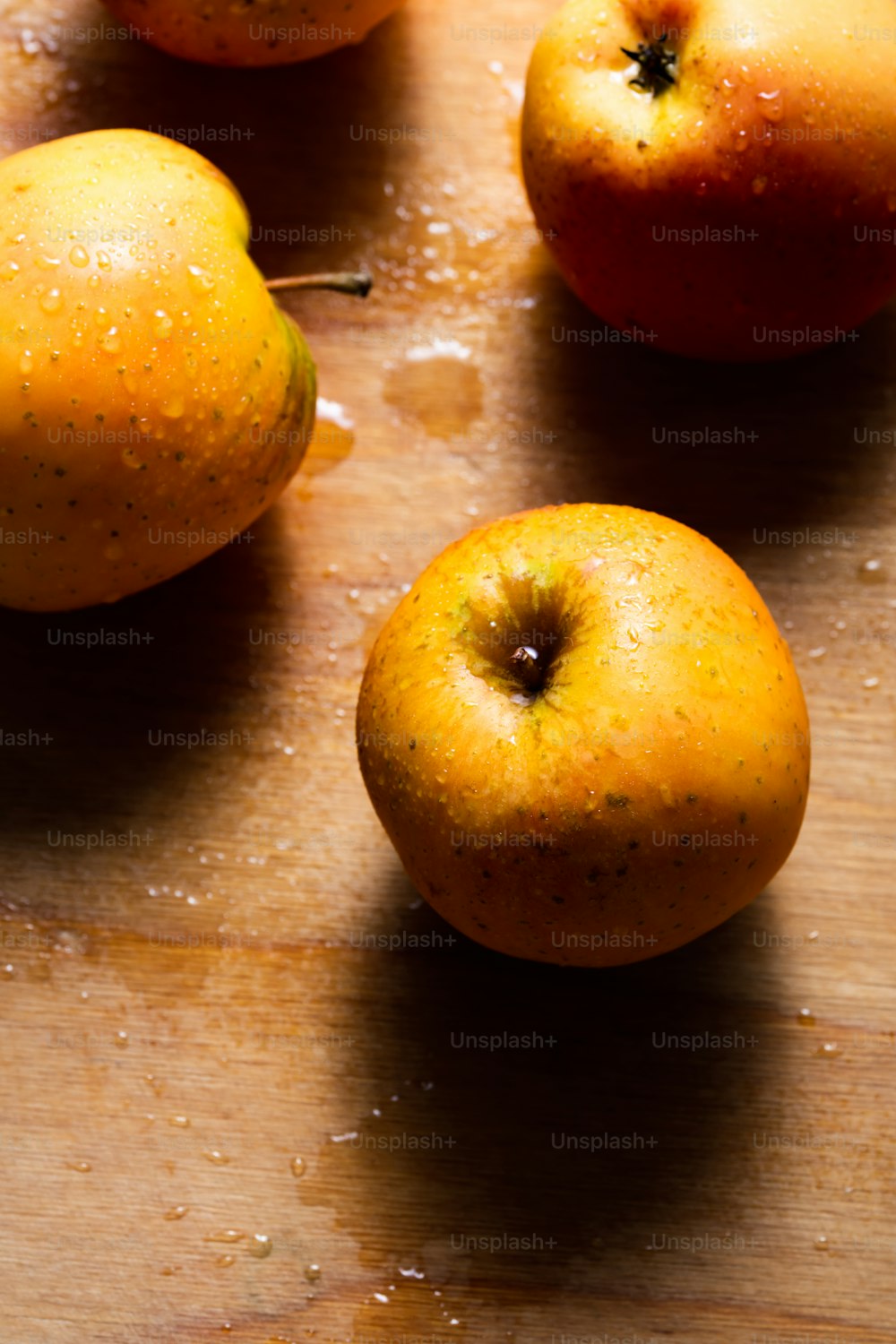 una tabla de cortar de madera cubierta con manzanas y naranjas