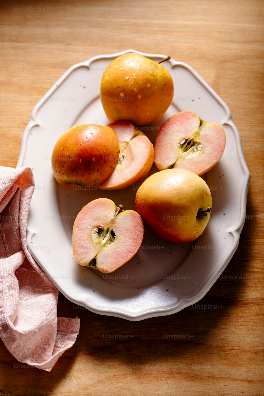 나무 테이블 위에 사과를 얹은 흰색 접시