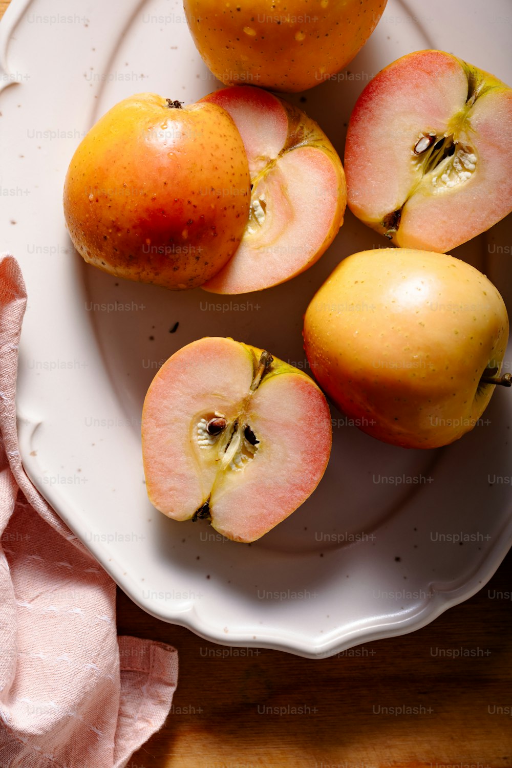 um prato branco coberto com maçãs e laranjas