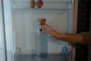 냉장고 앞에서 병을 들고 있는 사람