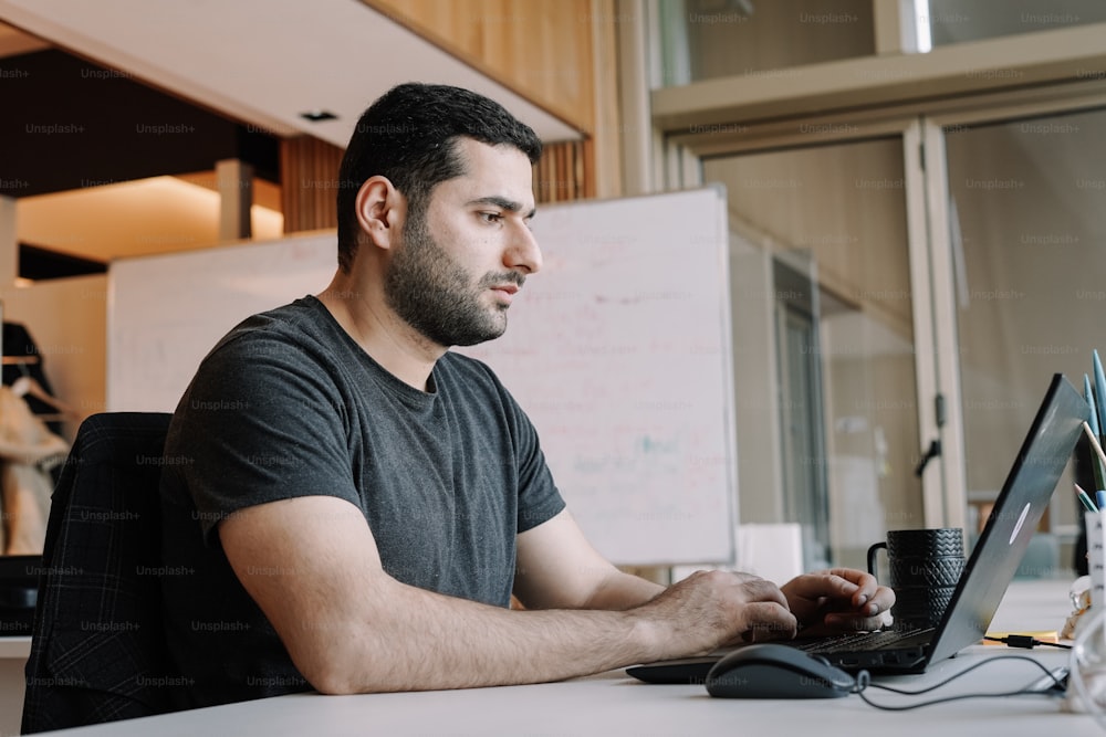 a man sitting in front of a laptop computer