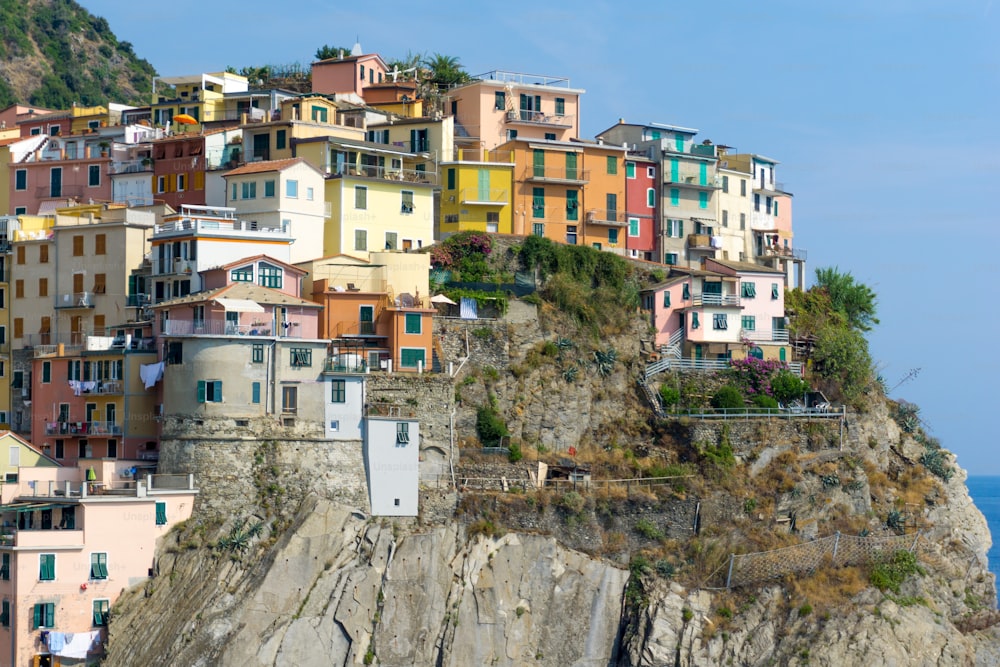 a bunch of houses on a cliff by the ocean